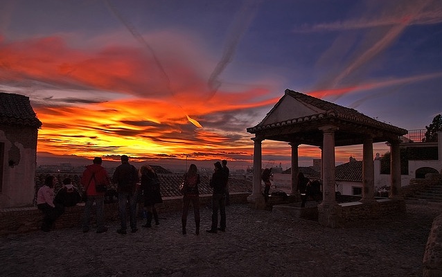 a group of people standing in front of a sunset