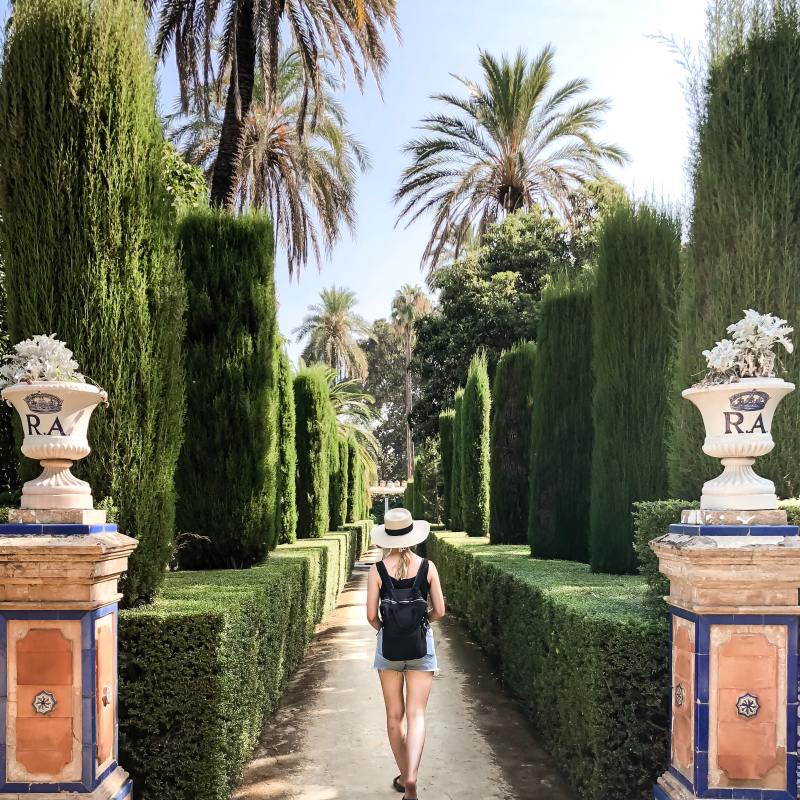una chica pasenado por el Alcazar de Sevilla