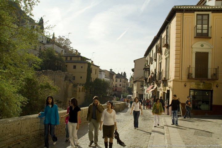 Gente andando por la carrera del Darro en Albaicín.