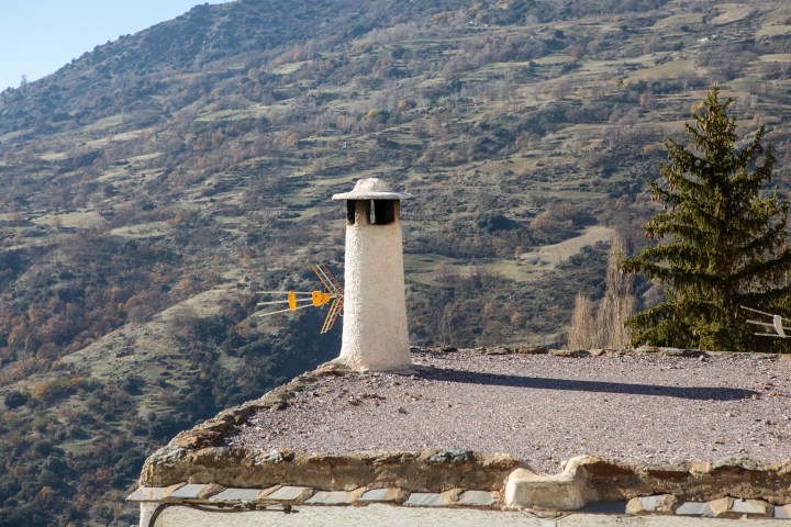 a view of a stone building with a mountain in the background