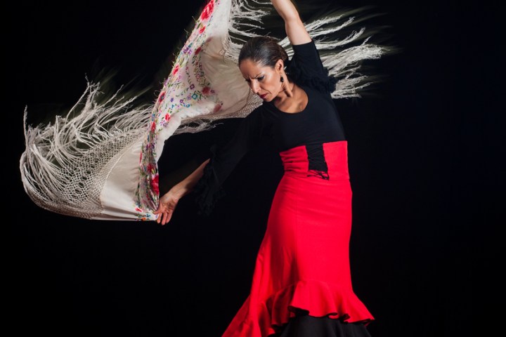 una chica bailando con un mantón blanco