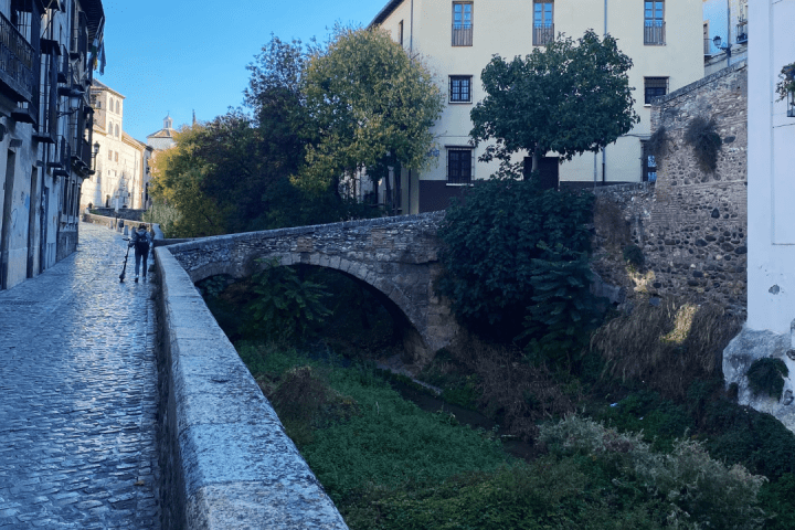 a large brick building with a clock on the side of a road