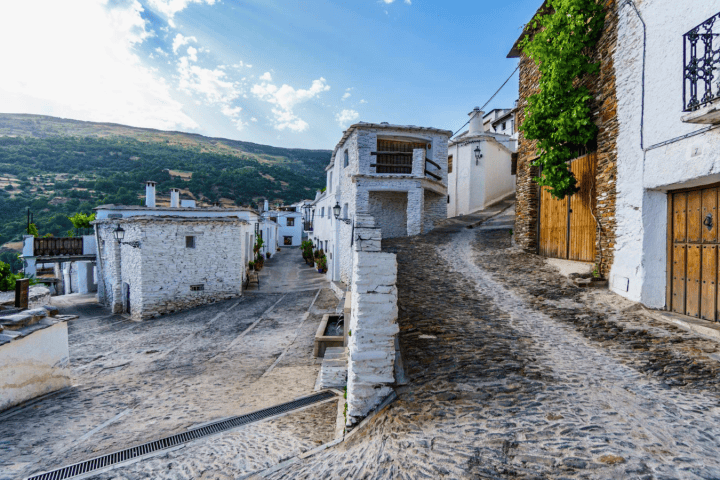 Quaint hillside village with narrow cobblestone streets and whitewashed buildings.